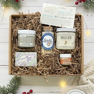 Gift set with candles, soap, and other items in a box, surrounded by Christmas decorations.