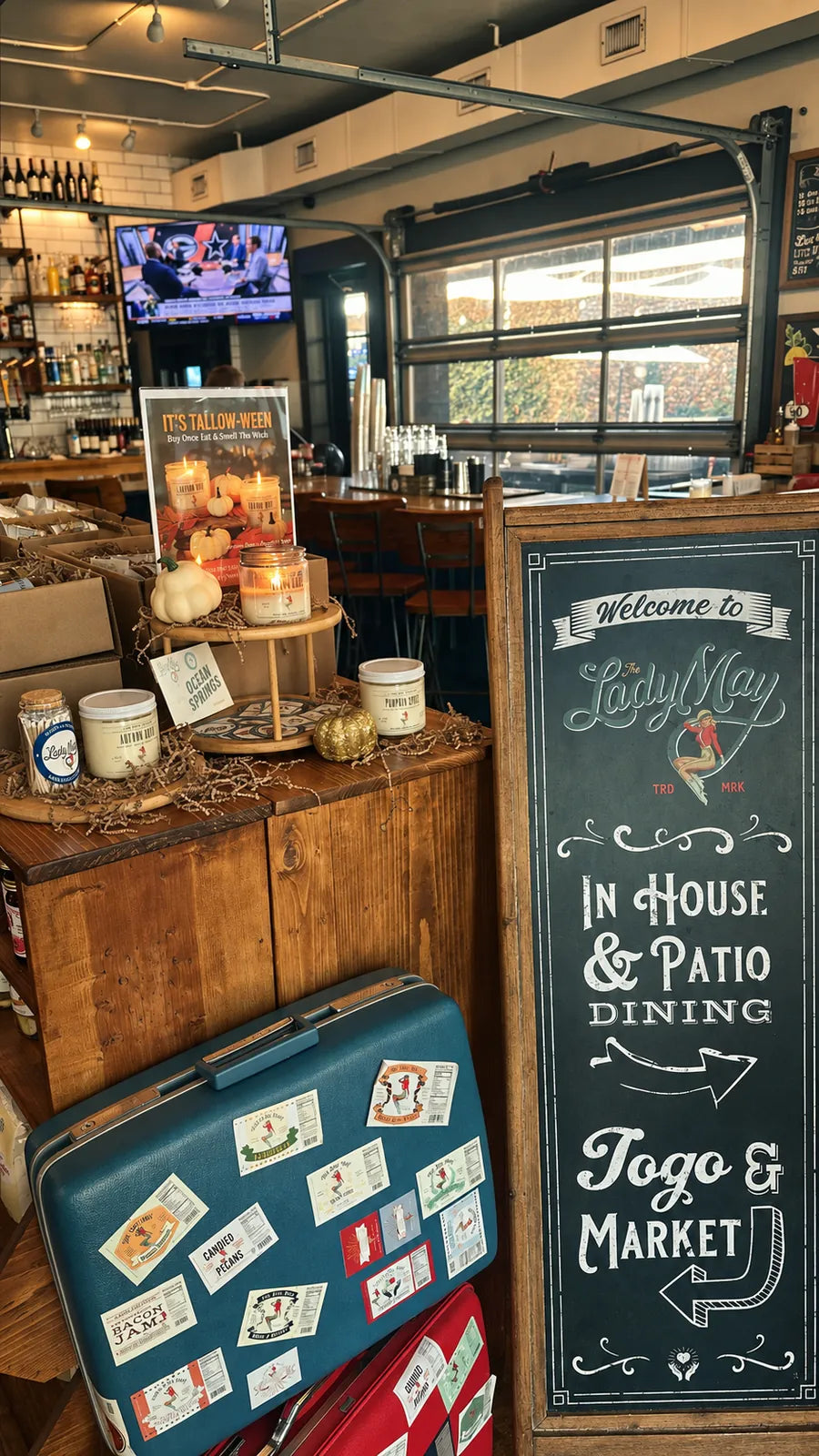Lady May restaurant entry with the hand-lettered dining and May’s Market sign