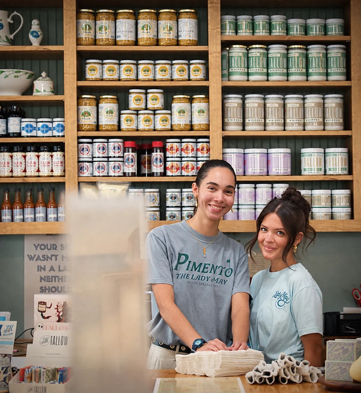 Two Lady May team members welcoming guests at the May’s Market counter